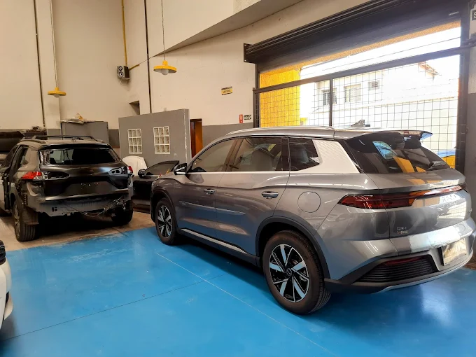 Interior da oficina Morauto com BYD Song Plus finalizado e carros em reparo de funilaria estrutural